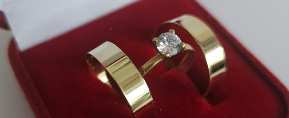 Aliança reta de 5 mm em ouro, em destaque sobre fundo neutro.
